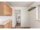 Mud room with wooden cabinets, hooks, and entrance to a laundry room with a washer and dryer at 3280 Ames St, Wheat Ridge, CO 80212