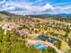 Beautiful aerial view of the community, showcasing the pond, tennis courts, and mountain views in the background at 23585 Genesee Village Rd # E, Golden, CO 80401
