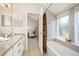 Bathroom featuring granite counters, double sinks, tile floors, and a tub with a window view at 23585 Genesee Village Rd # E, Golden, CO 80401