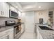 White kitchen featuring granite countertops, modern appliances, and ample cabinetry at 23585 Genesee Village Rd # E, Golden, CO 80401