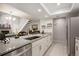 Modern kitchen flows into dining, blending white cabinetry, stainless appliances, and granite countertops at 23585 Genesee Village Rd # E, Golden, CO 80401