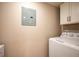 Laundry room with a white washer and dryer, upper cabinets, and neutral wall paint at 23585 Genesee Village Rd # E, Golden, CO 80401
