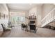 Sunlit living area with fireplace, seating, balcony access and staircase making a delightful gathering place at 23585 Genesee Village Rd # E, Golden, CO 80401
