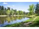 Scenic pond surrounded by lush greenery and a charming wooden bridge at 23585 Genesee Village Rd # E, Golden, CO 80401