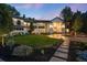 Elegant two-story home with manicured front lawn and stone walkway leading to a grand entrance framed by stylish lighting at 4736 S Fillmore Ct, Cherry Hills Village, CO 80113