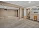 Open basement layout with neutral carpet, visible support beams, and access to the kitchenette at 4484 S Granby Ct, Aurora, CO 80015