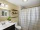 Well-lit bathroom with a shower-tub combo, decorative shelves, and a window for natural light at 4484 S Granby Ct, Aurora, CO 80015