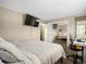 Bright bedroom featuring a mounted TV, large mirror closet, and a dedicated desk space at 4484 S Granby Ct, Aurora, CO 80015