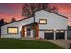 Inviting home exterior featuring a two-car garage, manicured lawn, and natural wood porch supports at dusk at 4484 S Granby Ct, Aurora, CO 80015