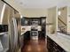 Modern kitchen featuring dark wood cabinets, stainless steel appliances, tile backsplash, and granite countertops at 4484 S Granby Ct, Aurora, CO 80015