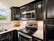 Updated kitchen features stainless steel microwave, range, and granite countertops at 4484 S Granby Ct, Aurora, CO 80015
