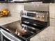 Close up of the stainless steel range, white subway backsplash and granite countertops at 4484 S Granby Ct, Aurora, CO 80015