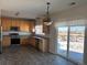 Kitchen with wood cabinets, stainless steel appliances, and view of backyard at 11729 Elkhart St, Commerce City, CO 80603