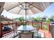 Inviting outdoor deck with a glass table, umbrella, and red railing, perfect for relaxing or entertaining at 9700 W 88Th Pl, Westminster, CO 80021