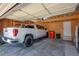 Spacious two car garage interior with a pickup truck, storage shelving, and an extra refrigerator at 9700 W 88Th Pl, Westminster, CO 80021