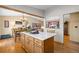 Bright kitchen features a central island, wood cabinets and flooring, with an open view of the dining and living areas at 9700 W 88Th Pl, Westminster, CO 80021