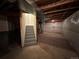 An unfinished basement with exposed ceiling and cement floors leads to a staircase and has a carpeted corner at 2033 Espana Way, Aurora, CO 80011