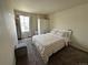 The bedroom has a queen bed with a tan and white checkered pattern. There is a closet and a large window at 2033 Espana Way, Aurora, CO 80011