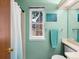 Mint green bathroom features a shower with a light blue curtain, toilet, and towel rack at 3086 W 107Th Pl # F, Westminster, CO 80031