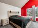 Comfortable bedroom with a bright red accent wall and a wooden headboard at 3086 W 107Th Pl # F, Westminster, CO 80031