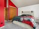 Bedroom features neutral carpet, a queen size bed, an ensuite, and red accent wall at 3086 W 107Th Pl # F, Westminster, CO 80031