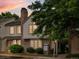 Charming two-story townhome with brick accents, mature landscaping, and a classic chimney at dusk at 3086 W 107Th Pl # F, Westminster, CO 80031