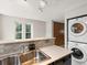 Contemporary kitchen with stainless steel sink and stacked washer/dryer units at 3086 W 107Th Pl # F, Westminster, CO 80031