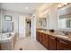Bright bathroom with double vanity, granite countertops, and a walk-in closet at 3102 Fox Sedge Pl, Highlands Ranch, CO 80126