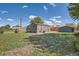 A view of a home's backyard with grass, a gray detached garage, gravel, and an above-ground area at 5555 Julian St, Denver, CO 80221