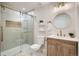Bathroom features modern fixtures, a vanity with storage, and a glass-enclosed shower with marble tiles at 5555 Julian St, Denver, CO 80221