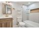 Elegant bathroom featuring wood cabinet, gold hardware, shelves, and tiled walls for a luxurious experience at 5555 Julian St, Denver, CO 80221
