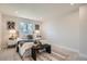 Bright bedroom features neutral decor, a decorative carpet, and a large window bringing in natural light at 5555 Julian St, Denver, CO 80221