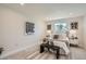Bright bedroom features neutral decor, a decorative carpet, and a large window bringing in natural light at 5555 Julian St, Denver, CO 80221