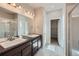 Bathroom with dual vanity, large mirror, and walk-in closet at 11926 Barrentine Loop, Parker, CO 80138