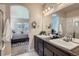 Bathroom featuring double sinks, dark cabinets, large mirrors, and an open archway at 11926 Barrentine Loop, Parker, CO 80138