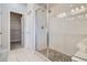 Bathroom with a walk-in shower featuring glass doors and white tile and pebble flooring at 11926 Barrentine Loop, Parker, CO 80138