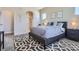 Comfortable bedroom showcases a gray bed, patterned rug, neutral walls, and arched doorway at 11926 Barrentine Loop, Parker, CO 80138
