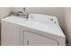 Laundry area features a white top-load washing machine and a matching front-load dryer with control panels at 11926 Barrentine Loop, Parker, CO 80138