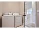 Well-lit laundry room with side-by-side washer and dryer; doorway to the main hallway at 11926 Barrentine Loop, Parker, CO 80138