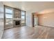 Bright living room featuring a stone fireplace, hardwood floors, and large windows at 11926 Barrentine Loop, Parker, CO 80138