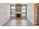 Bright living room featuring a stone fireplace, hardwood floors, and large windows at 11926 Barrentine Loop, Parker, CO 80138