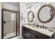 Bathroom featuring a double sink vanity with granite countertop and tiled shower with glass enclosure at 4318 Fossil Way, Castle Rock, CO 80109