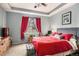 Bedroom with red and grey bedding, and a window with decorative curtains at 4318 Fossil Way, Castle Rock, CO 80109