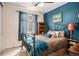 Cozy bedroom with a metal frame bed, blue accent wall, and natural light at 4318 Fossil Way, Castle Rock, CO 80109