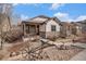 Charming home featuring a covered porch, rock landscaping with decorative metal wheel, and stone accents at 4318 Fossil Way, Castle Rock, CO 80109