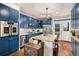 Well-equipped kitchen featuring custom blue cabinetry, granite countertops, and stainless steel appliances at 4318 Fossil Way, Castle Rock, CO 80109