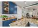 Kitchen island with granite countertops and a stainless steel sink under cabinet lighting and hardwood flooring at 4318 Fossil Way, Castle Rock, CO 80109