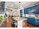 Bright kitchen features blue cabinets, a granite island, and hardwood floors open to the home's dining and living spaces at 4318 Fossil Way, Castle Rock, CO 80109