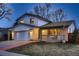 Inviting exterior view showcasing a charming house with a brick-accented facade, covered porch, and lush lawn at 8485 W 74Th Dr, Arvada, CO 80005