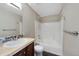Bathroom featuring a single sink vanity with tile backsplash and a shower-tub combo at 8437 Thunder Ridge Way # 202, Highlands Ranch, CO 80126